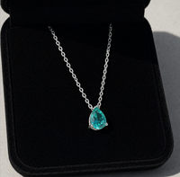 Paraiba Tourmaline Pear Cut Pendant Necklace on a black background