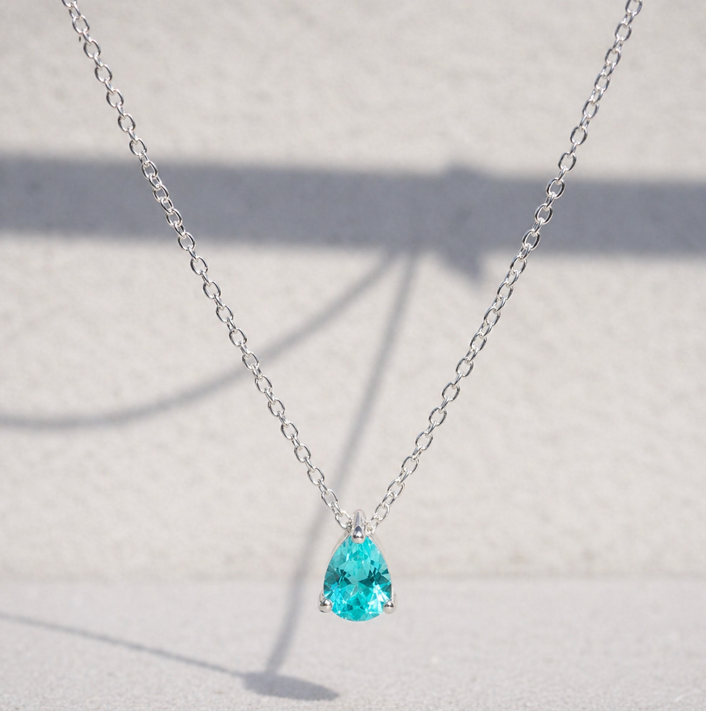 Paraiba Tourmaline Pear Cut Pendant Necklace on a white background