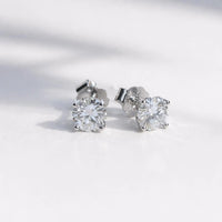 Pair of moissanite stud earrings on a light gray background
