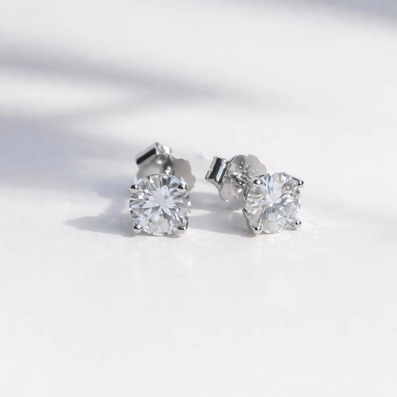 Pair of moissanite stud earrings on a light gray background
