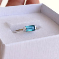 Silver ring with a london blue topaz gemstone on a white cushion