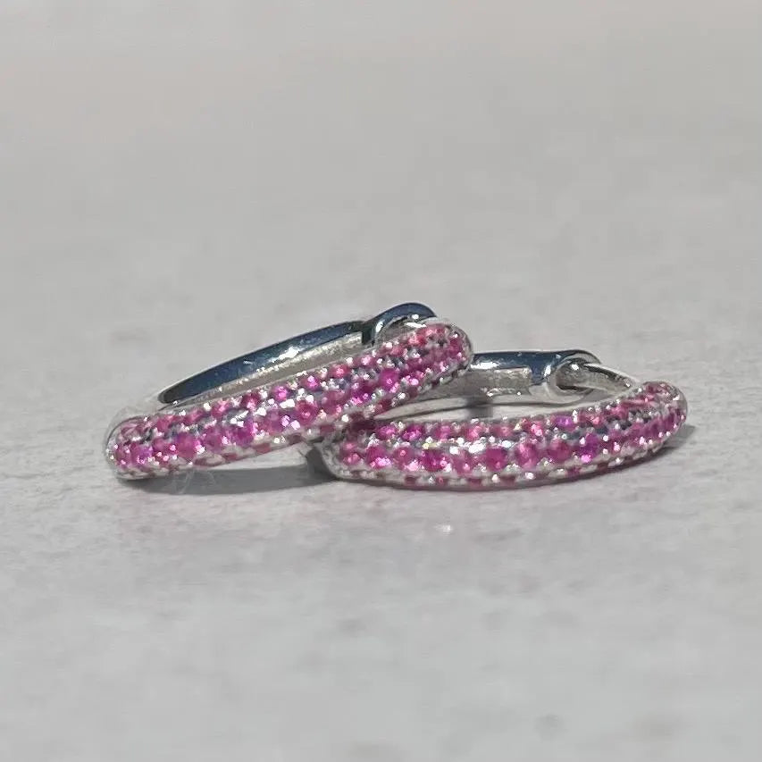 Pair of pink hoop earrings on a light gray background