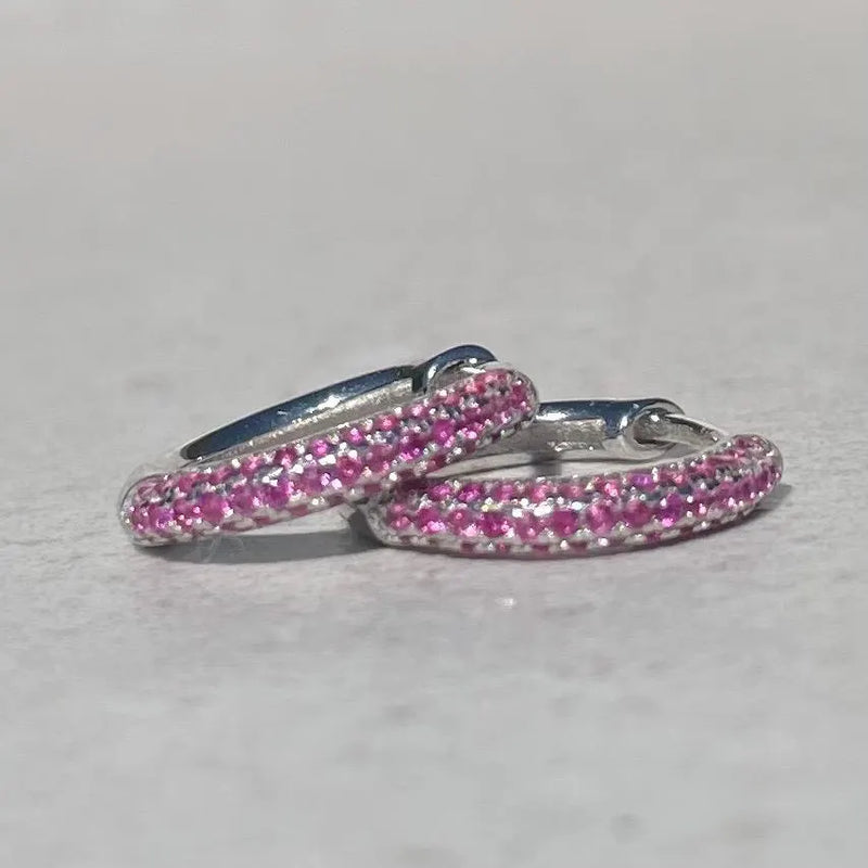 Pair of pink hoop earrings on a light gray background